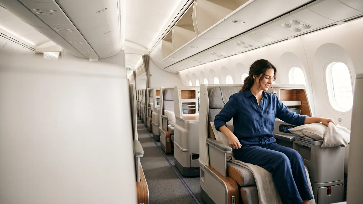 La cabina business de un avión con asientos amplios, vista desde el pasillo